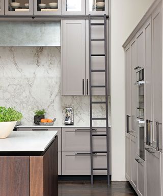 grey kitchen with tall cabinets and ladder