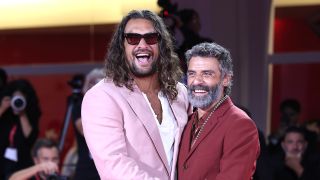 Momoa and Isaac hugging on the red carpet premiere of In the Hand of Dante in Venice.