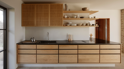 wooden scandi kitchen with black counters and open shelving above