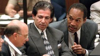 LOS ANGELES, UNITED STATES:Murder defendant O.J. Simpson (R) consults with friend Robert Kardashian (C) and Alvin Michelson (L), the attorney representing Kardashian, during a hearing about K