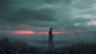 Morpheus steht während eines Sonnenuntergangs in der Netflix-Fernsehserie The Sandman in einer kargen Landschaft, mit seinem magischen Helm auf dem Kopf.