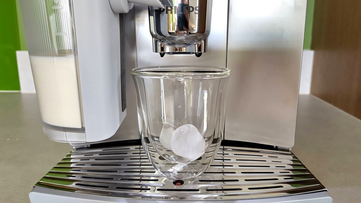 Philips Cafe Aromis Series 8000 coffee maker ready to dispense coffee into glass cup containing ice