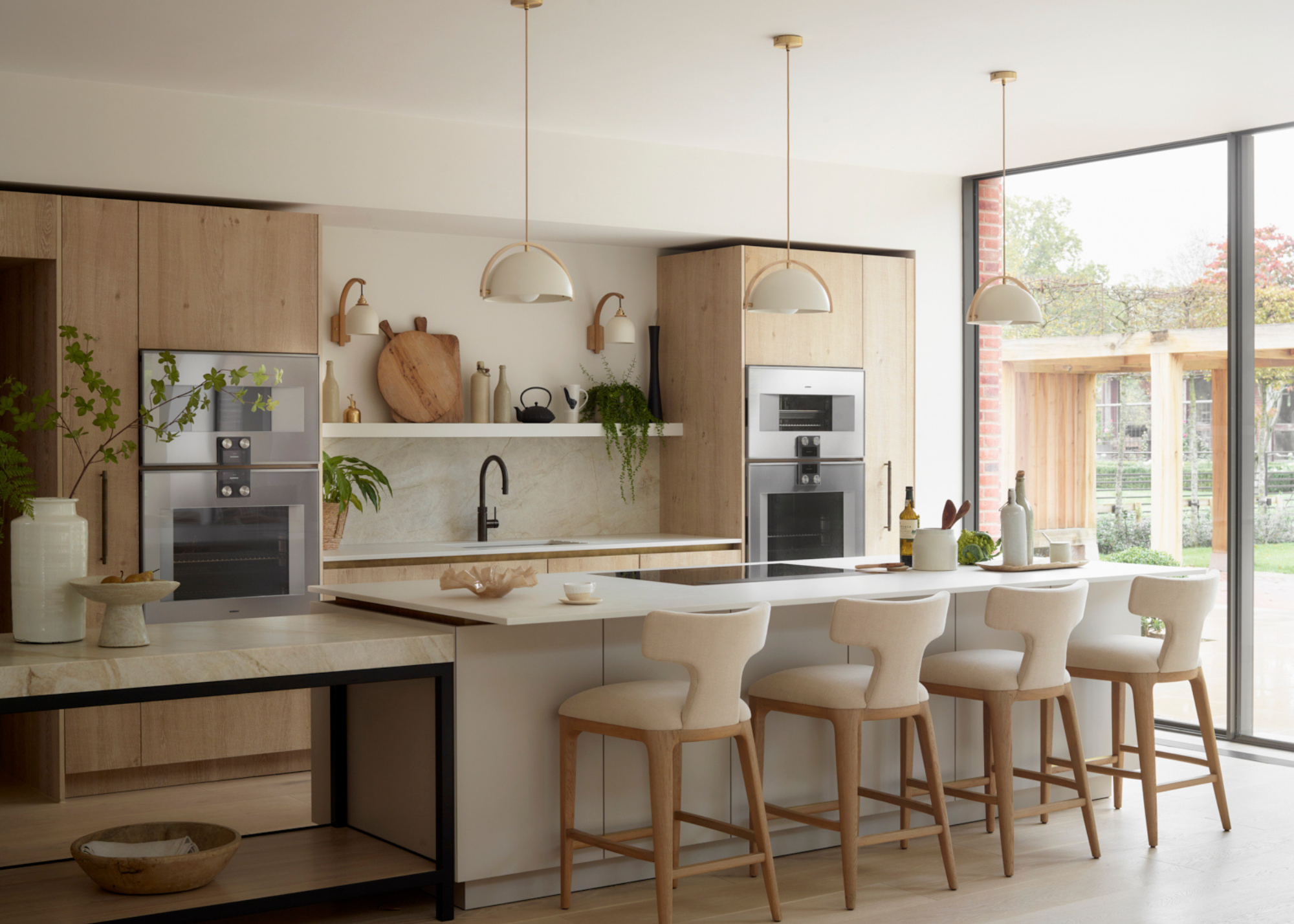 large modern kitchen in neutral tones with pendant lights and bar seating