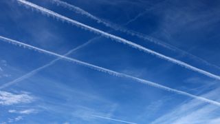 Blue sky with several contrails marking the flight paths of planes.