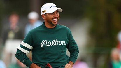 Jason Day smiles wearing a green Malbon sweater ahead of the 2024 Masters