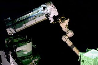 ESA astronaut Thomas Pesquet, mounted to the Canadarm2 robot arm, maneuvers the first ISS Roll-Out Solar Array (iROSA) outside of the International Space Station on June 16, 2021.