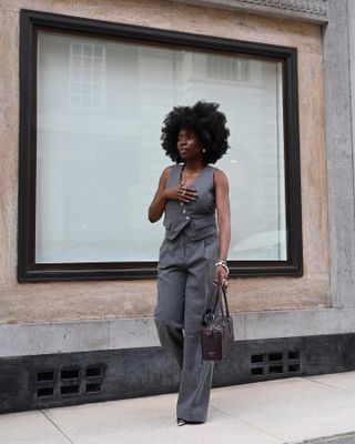 @daniellejinadu wears a grey waistcoat and trouser co-ord with pointed-toe shoes