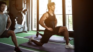 Two men holding static hip flexor stretch