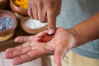 picture of a man with the carmine red powder paste in his hand - gettyimages - 1487588677