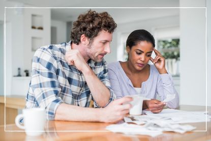 couple sitting at table at home looking over their household bills