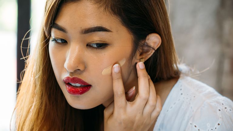 woman applying foundation