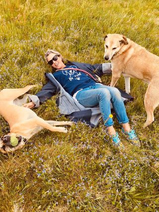 Woman lying in the grass with her dogs