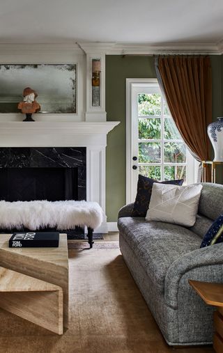 Green and white living room with large fireplace