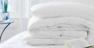 bedding folded on an unmade bed to support menopause-friendly bedding