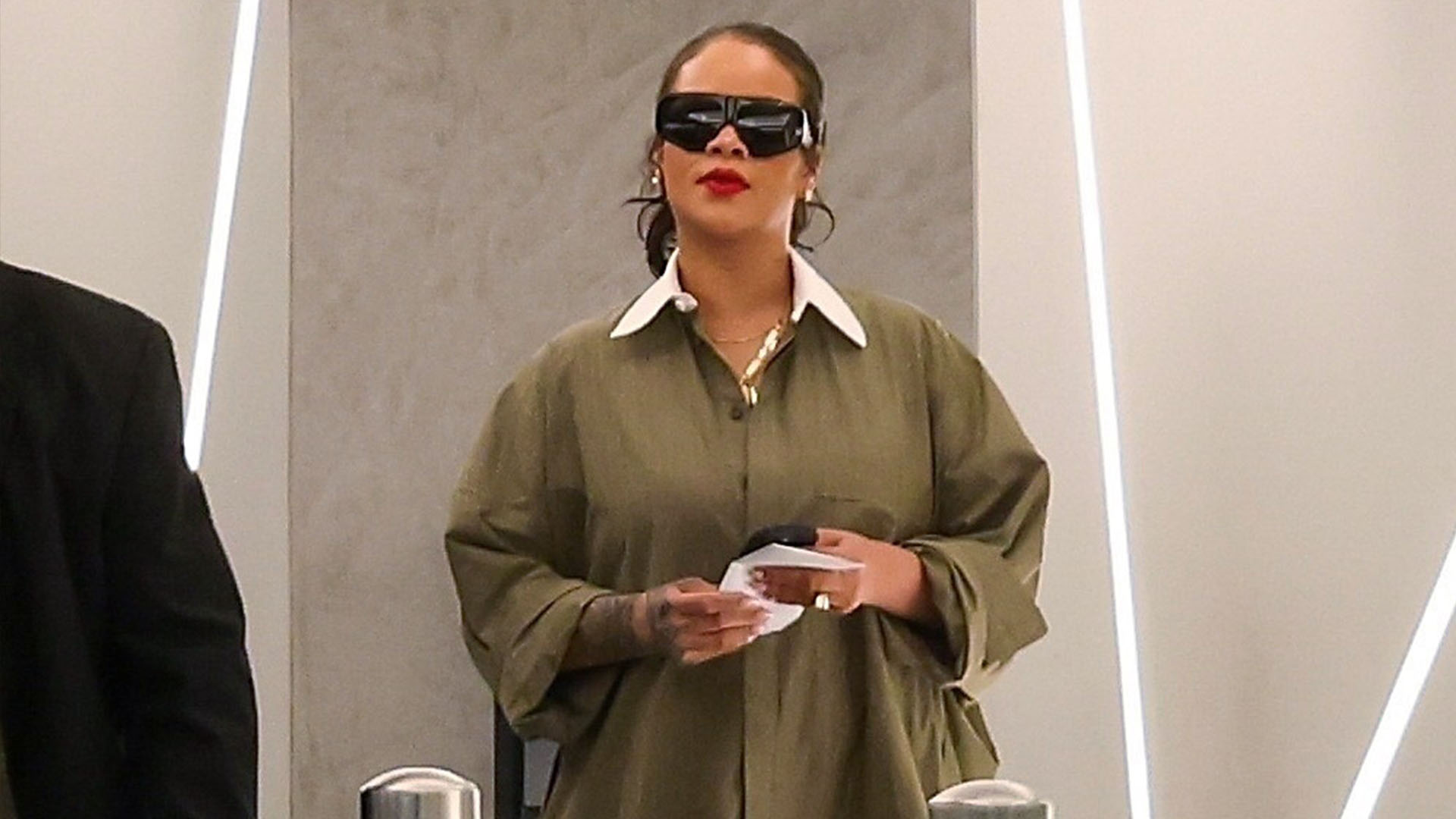 Rihanna wearing a green shirt dress and snakeskin boots