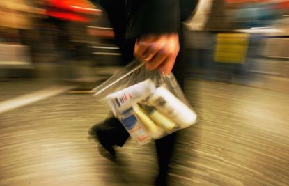 Airport employee carries a plastic bag with liquid containers
