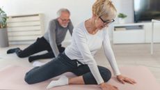 Woman and man stretching hips at home