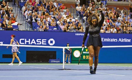 Serena Williams raises a hand triumphantly at the U.S. Open.