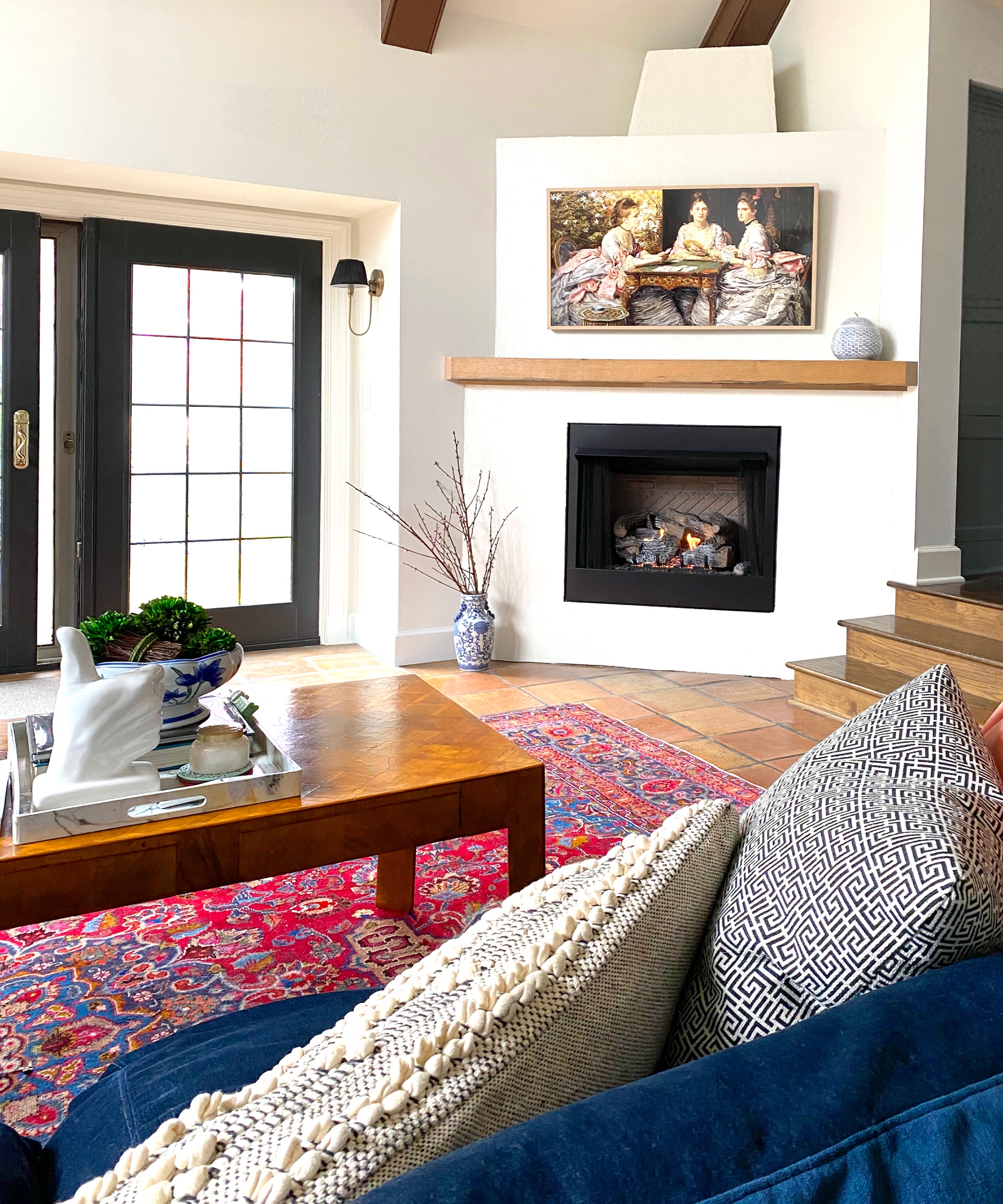 Fireplace in white hearth behind warm colored sofa