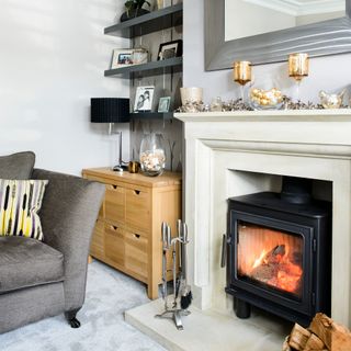 room with grey sofa candle stand and fireplace