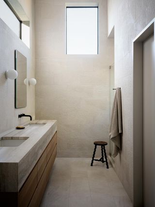 A naturally lit bathroom with sconces either side of the mirror