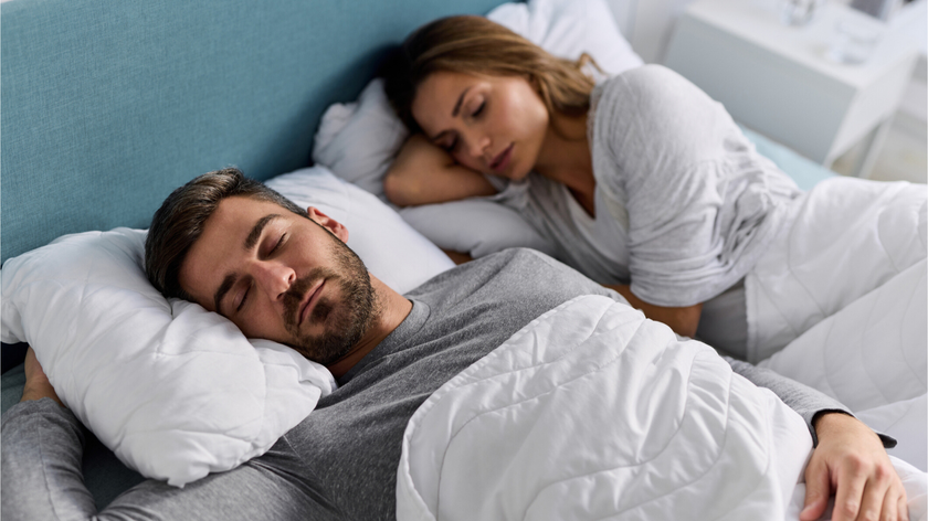 A man and a woman sleeping in bed