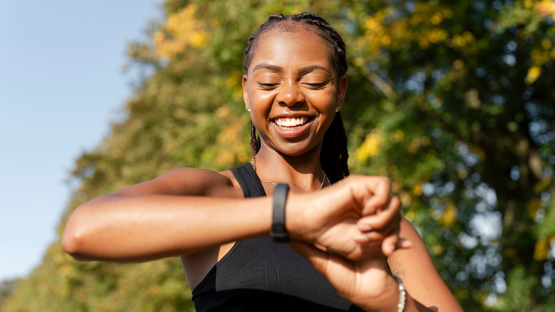 A young woman checking her fitness watch during a workout outdoors