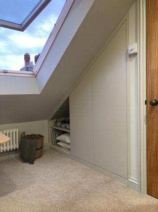 An IKEA pax wardrobe built into a small alcove in an attic room