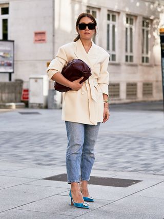 how to wear cropped flare jeans shown on a woman wearing cropped jeans with a white blazer and blue pumps