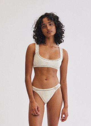 a model wears a white crochet bikini with a scoopneck
