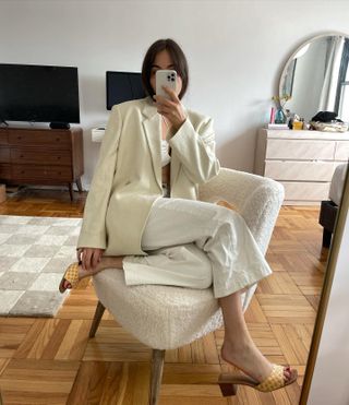 Anna LaPlaca wearing white cropped jeans, mules, a blazer, and a cropped top.