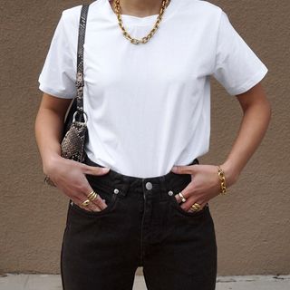 a woman wears a white crewneck t-shirt tucked into black jeans