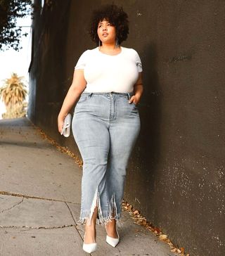 a woman wears a white crewneck T-shirt with jeans and white heels