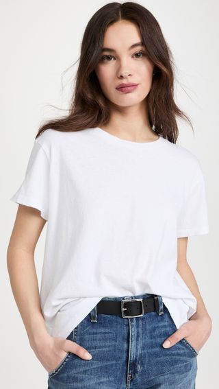 a model wears a white crewneck T-shirt with a black belt and jeans