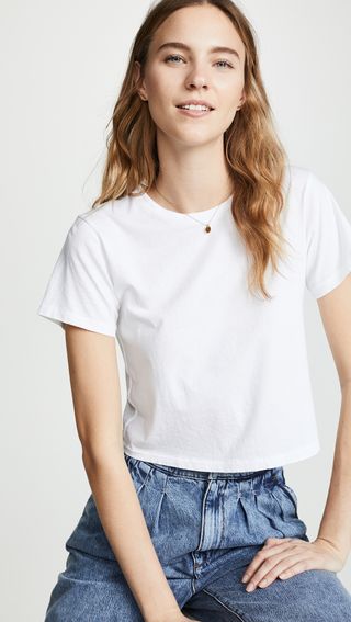 a model wears a white crewneck cropped T-shirt with jeans