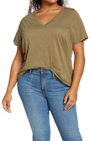 a model wears a green V-neck T-shirt with jeans