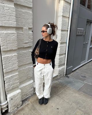 @rubylyn_ wearing cropped black cardigan, white cargo pants, and black sneakers