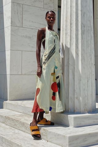 a woman's outfit with tan flat chunky sandals with a printed halter dress