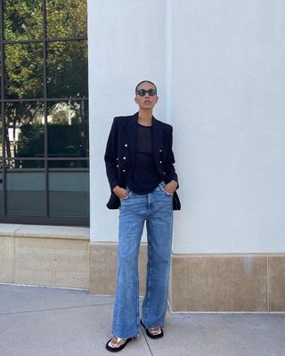 woman's outfit with bootcut jeans, t-shirt, and black blazer