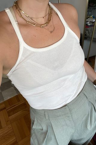 close-up shot of Anna LaPlaca wearing white tank top and green trousers