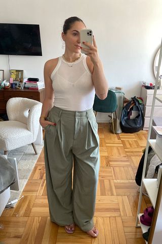 Anna LaPlaca wearing white tank top and green trousers