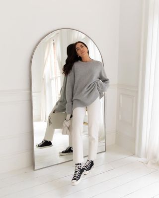 Jessica wears her Converse with some white slim-leg jeans and a cashmere knit.