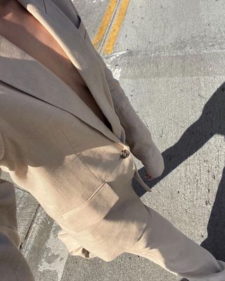 a photo of a woman wearing one of the best oversized blazers, more specifically a tan blazer with matching trousers