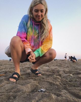 @aemiliafay wearing tie-dye sweatshirt with black Birkenstocks