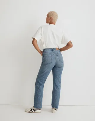 Woman standing on white background wearing Madewell The Curvy '90s Straight Jean with back to camera