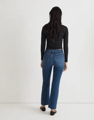 Woman wearing Madwell Kick Out Crop Jeans with black long sleeve shirt, back to camera