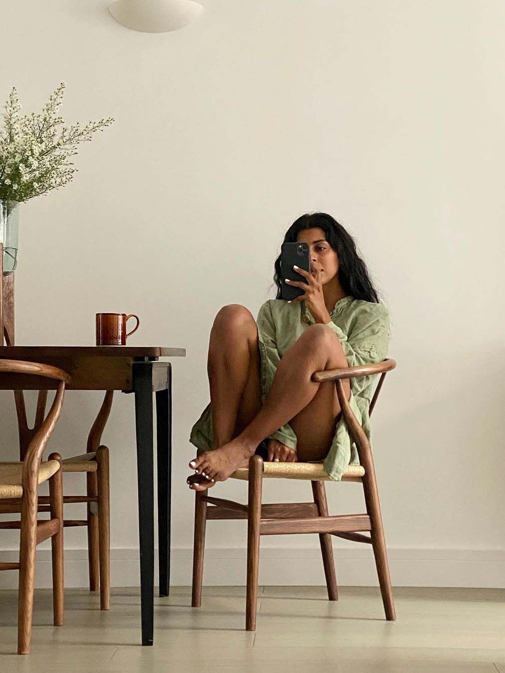 Mirror selfie of a woman at home with bare legs.