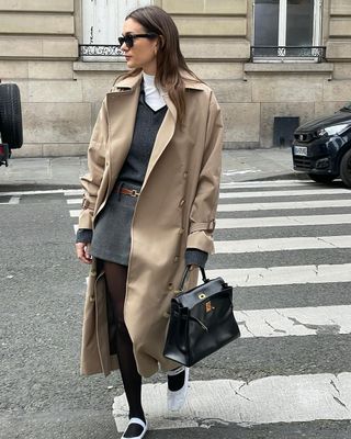 Anne styles her trench coat with a knit vest and mini skirt.