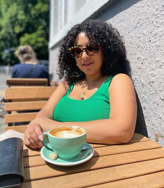 Woman with curly hair sitting outside