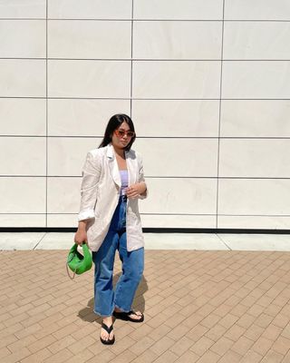 a woman's outfit with platform thong sandals, jeans, a tank, and a blazer